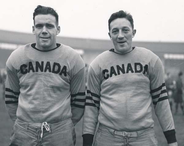 two men in football uniform with CANADA across front