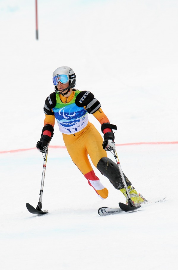 photograph skier racing on single ski with two outrigger skis on arms