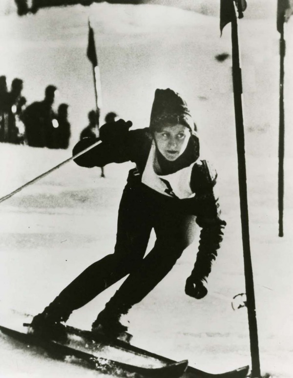 photograph of Anne Heggtveit skiing wearing bib #3 and sunglasses