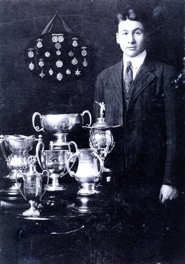 Photograph of Alex Decoteau with trophies and medals