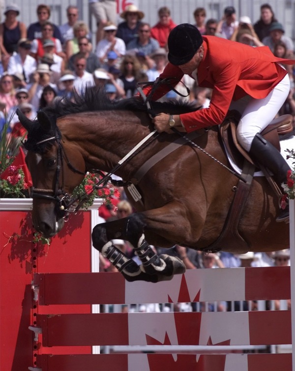 Ian Millar jumping his horse over Canada jump