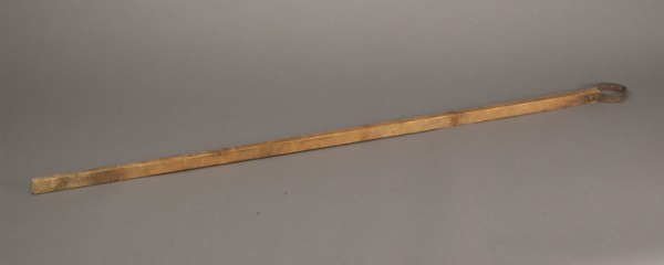 wooden stick with circular metal bracket at one end
