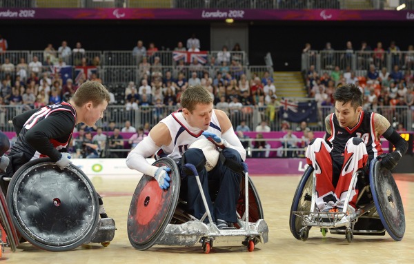 photograph of three players competing in wheelchair rugby