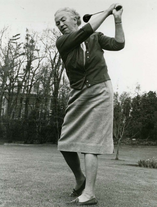 photograph of an older Ada Mackenzie swinging golf club