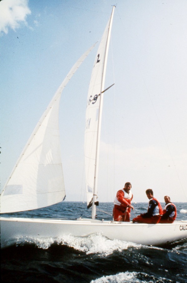 photograph of three men sailing in boat
