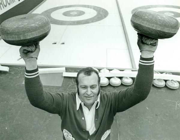 Photograph of Hector Gervais holding up two curling stones