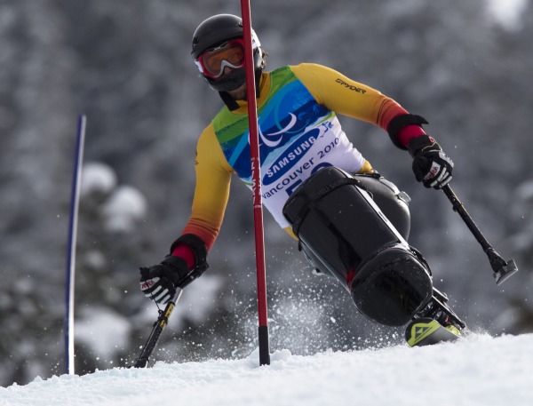 photograph of skier in sit ski racing through poles