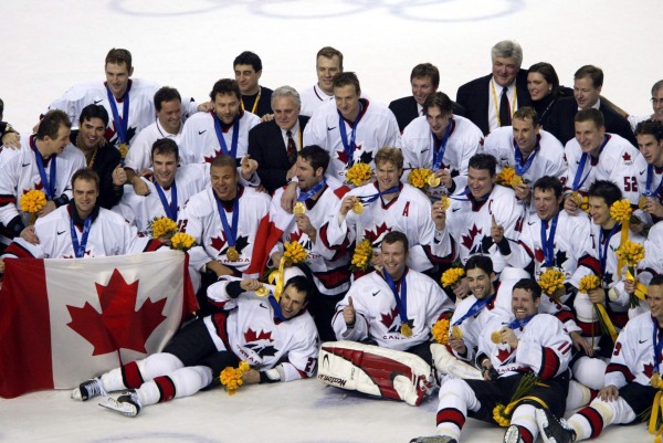 photograph of Team Canada with gold medals at centre ice