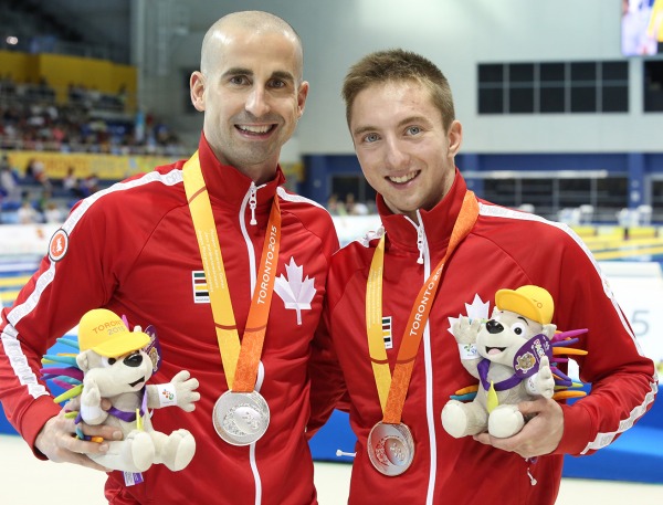 photograph of Benoit Huot and Alexander Elliot with medals and mascots