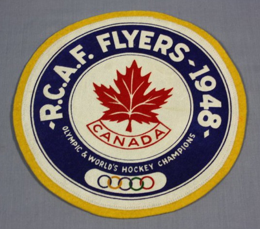 circular crest which reads RCAF Flyers 1948 Olympic & World's Hockey Champions with red maple leaf and CANADA in center.