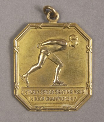 octagonal gold medal with image of speed skater