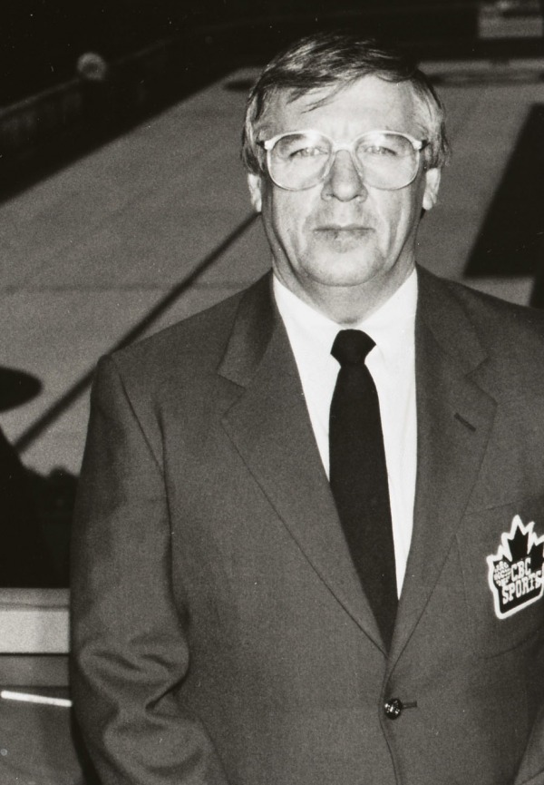 Photograph of Don Duguid in a suit with CBC Sports crest