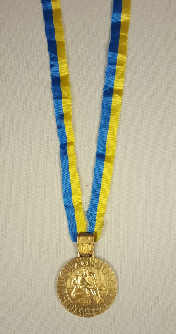 gold medal on yellow and blue ribbon