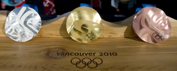 three Olympic medals on wood base