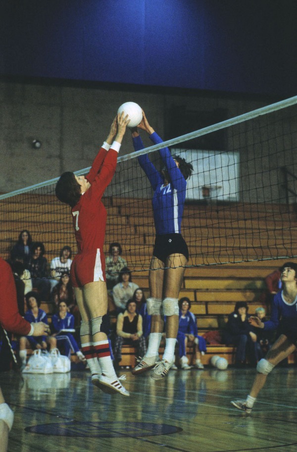 Photograph of two players jumping at a volleyball net