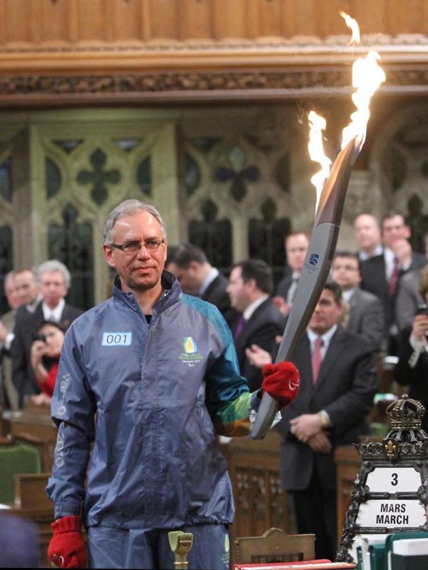 Photograph of Arnold Boldt holding 2010 Vancouver Games torch