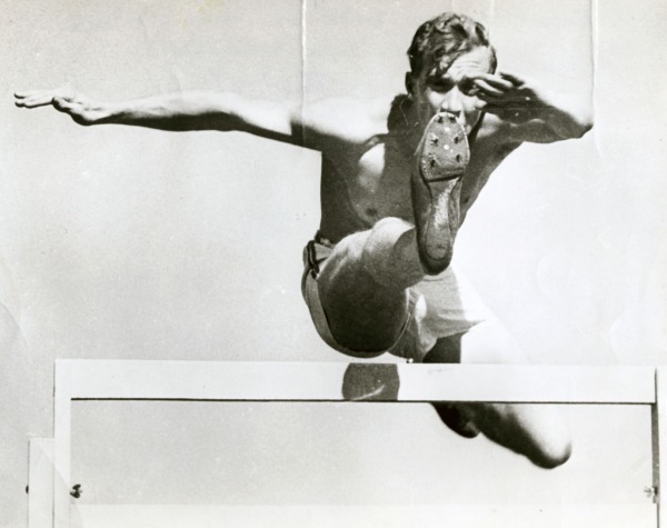 photograph of John Loaring jumping over hurdle