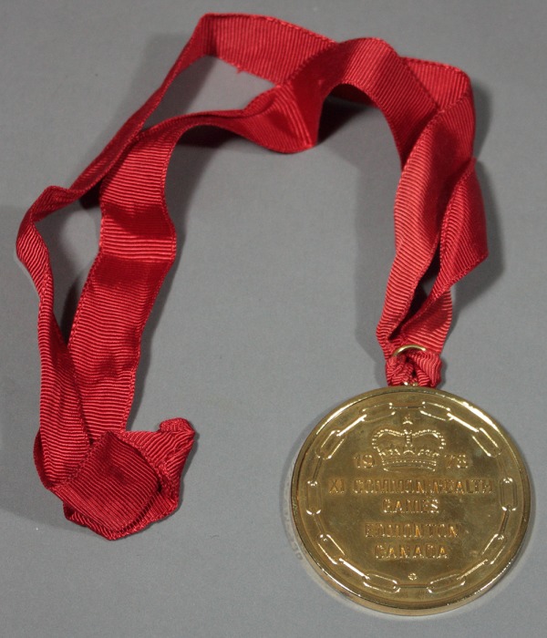 Gold medal with linked chain and crown on red ribbon