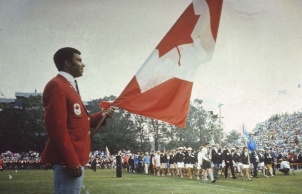 Photograph of Harry Jerome holding Canadian flag