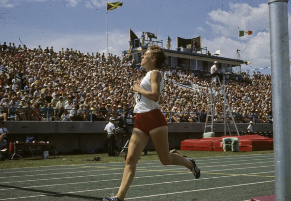 photograph of Abby Hoffman racing with crowd in background