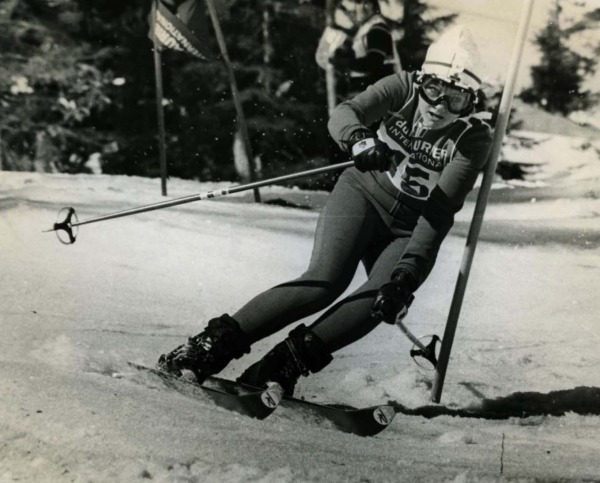 photograph of Betsy Clifford skiing downhill around ski pole