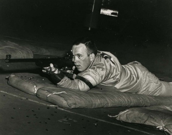 Photograph of Gerry Ouellette lying down on the ground shooting rifle